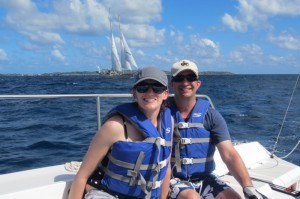 A couple in blue life jackets on a sailboat