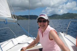 Closeup of a woman steering an Offshore Sailing School Colgate 26 in Roadtown Harbor, British Virgin Islands