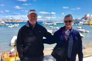 Couple posing in front of a dock of boats