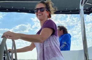 Woman at helm of a catamaran under sail