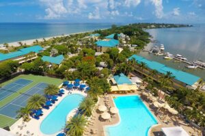 Aerial photo of 'Tween Waters Island Resort & Spa on Captiva Island, FL showing tennis courts, two pools, beach on left and harbor on right