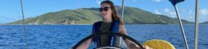 Student on a boat with a hill at the background