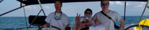 A group of three friends posing for a photo on a boat