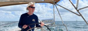 Man steering a large sailboat