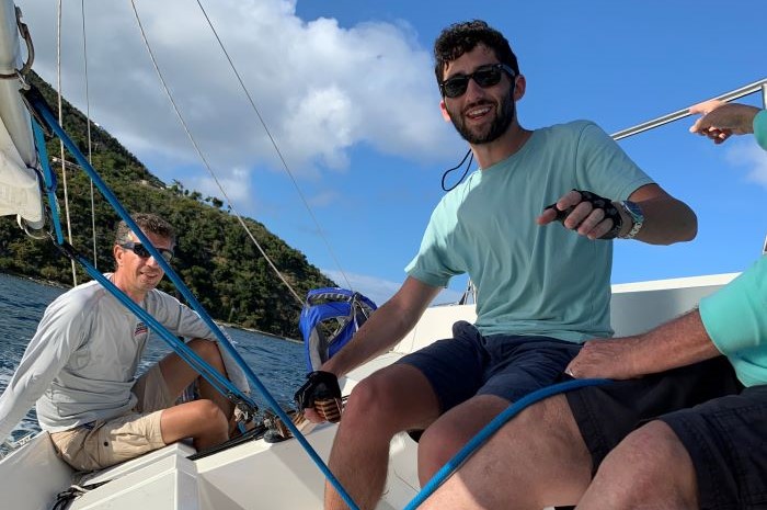 Instructor and man at helm of sailboat with tiller