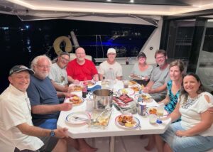 Group having dinner in cockpit of sailboat