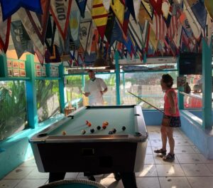 Playing pool with yacht club flags above