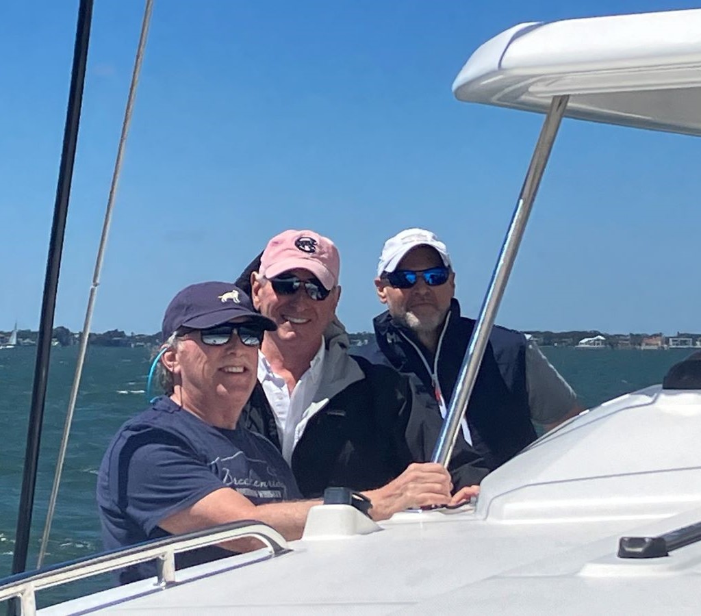 three guys on a catamaran sailboat