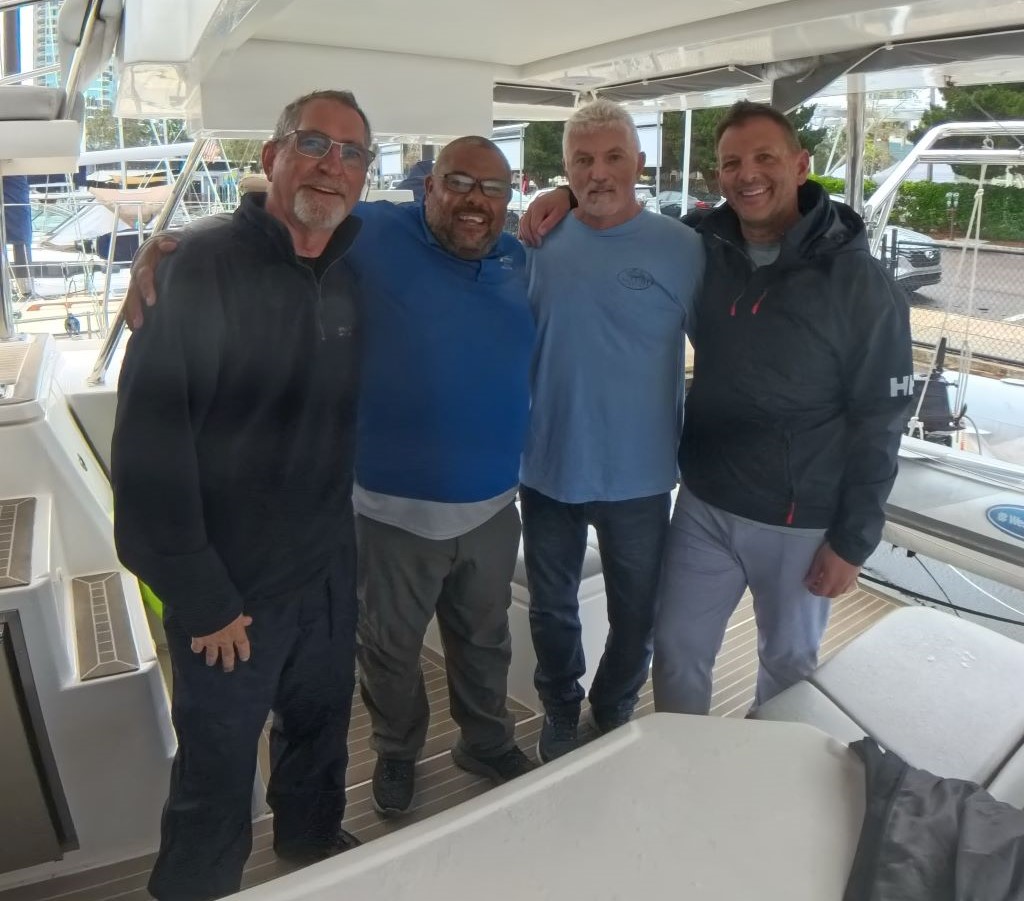 three men with Offshore Sailing School instructor on a sailboat