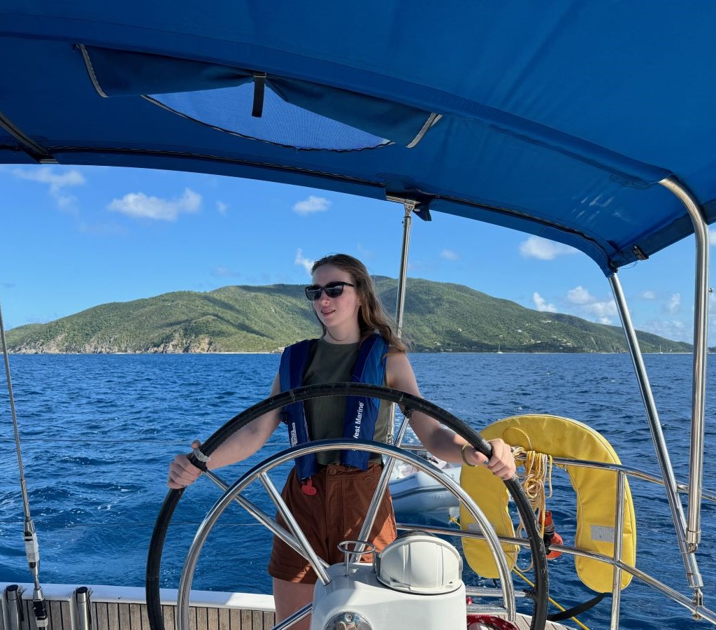 Teenage girl steering a monohull sailboat in British Virgin Islands
