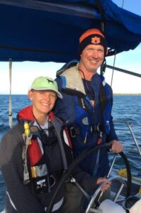 Man and woman in cockpit of a sailboat on Offshore Sailing School passage making course